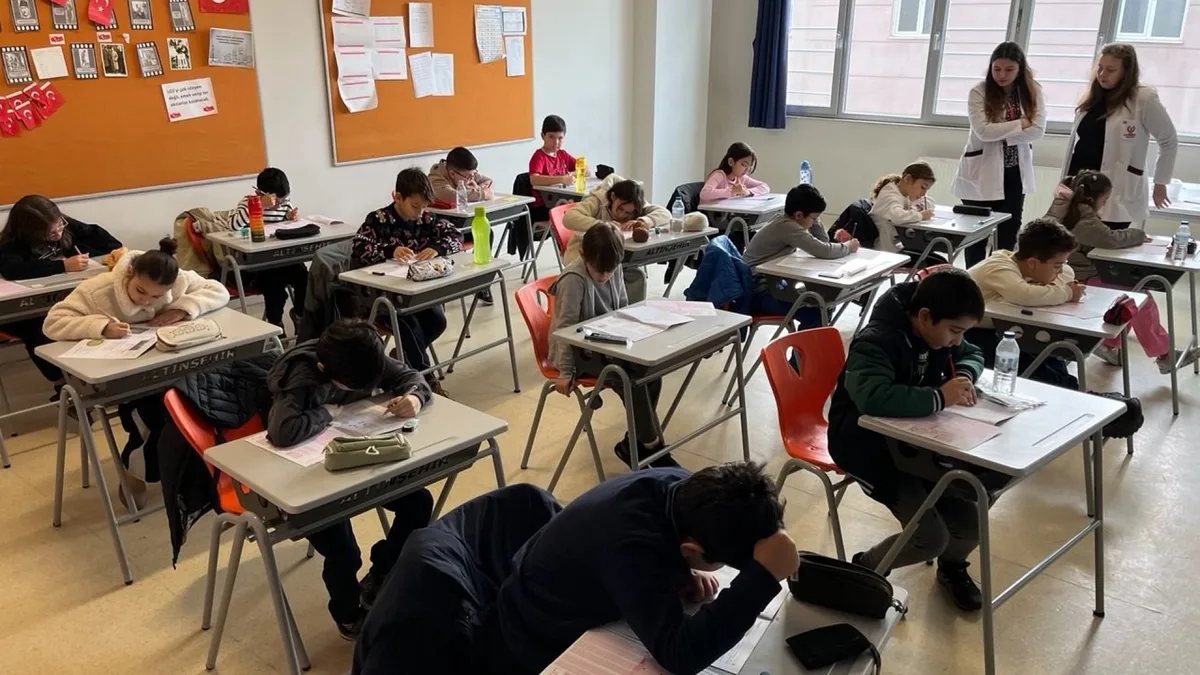 Sınıfta yazılı sınav kağıdı üzerinde çalışan öğrenciler
